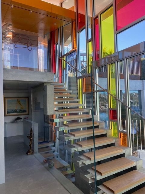 A staircase with a glass railing and colorful windows