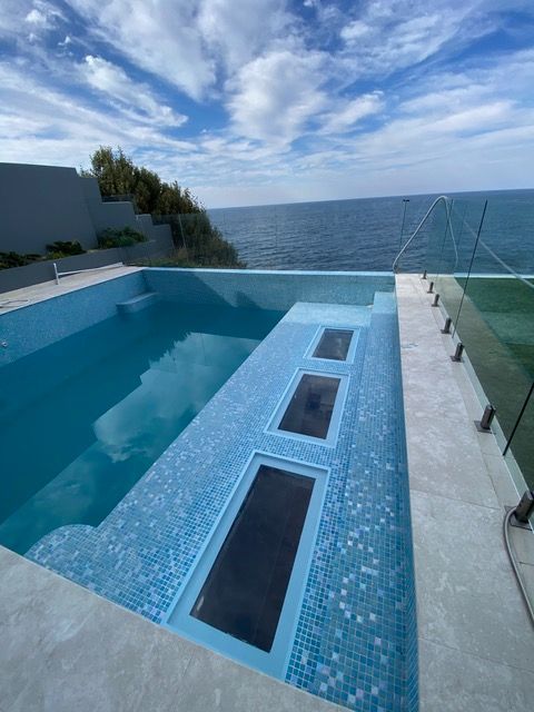 A large swimming pool with a view of the ocean