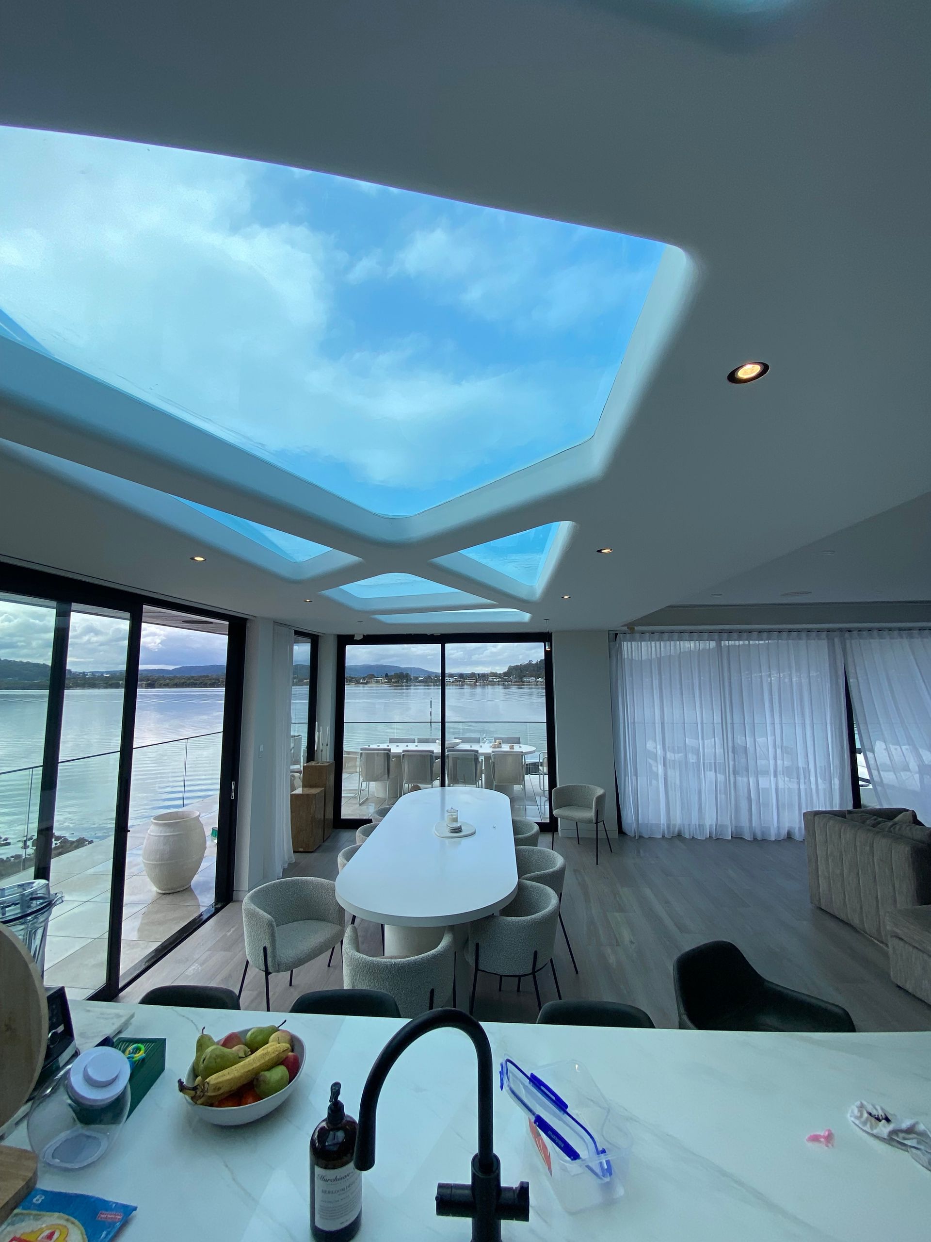 A kitchen with a table and chairs and a skylight above it