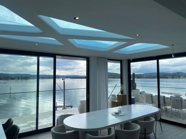 A dining room with a table and chairs overlooking a body of water