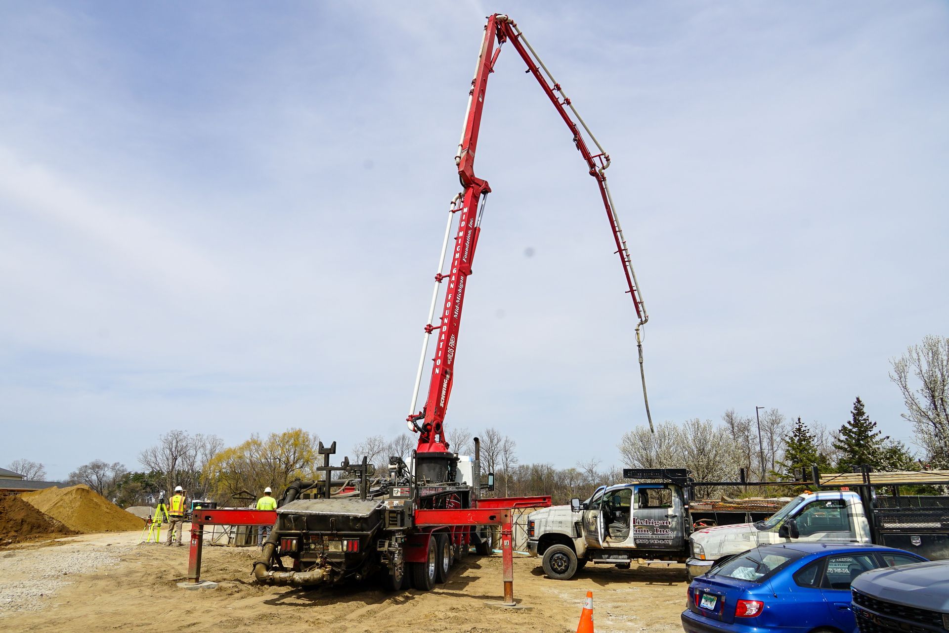 A concrete pump is being used to pour concrete on a construction site.