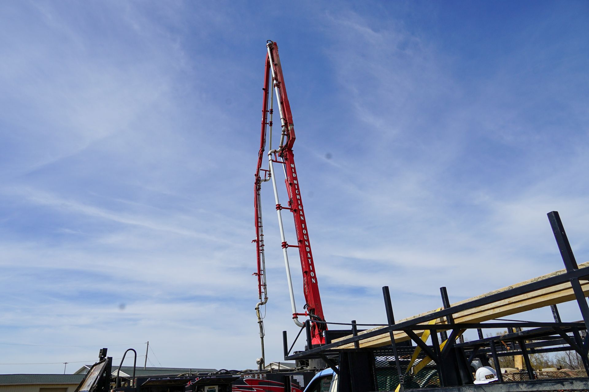 A concrete pump is being used to pour concrete into a building.