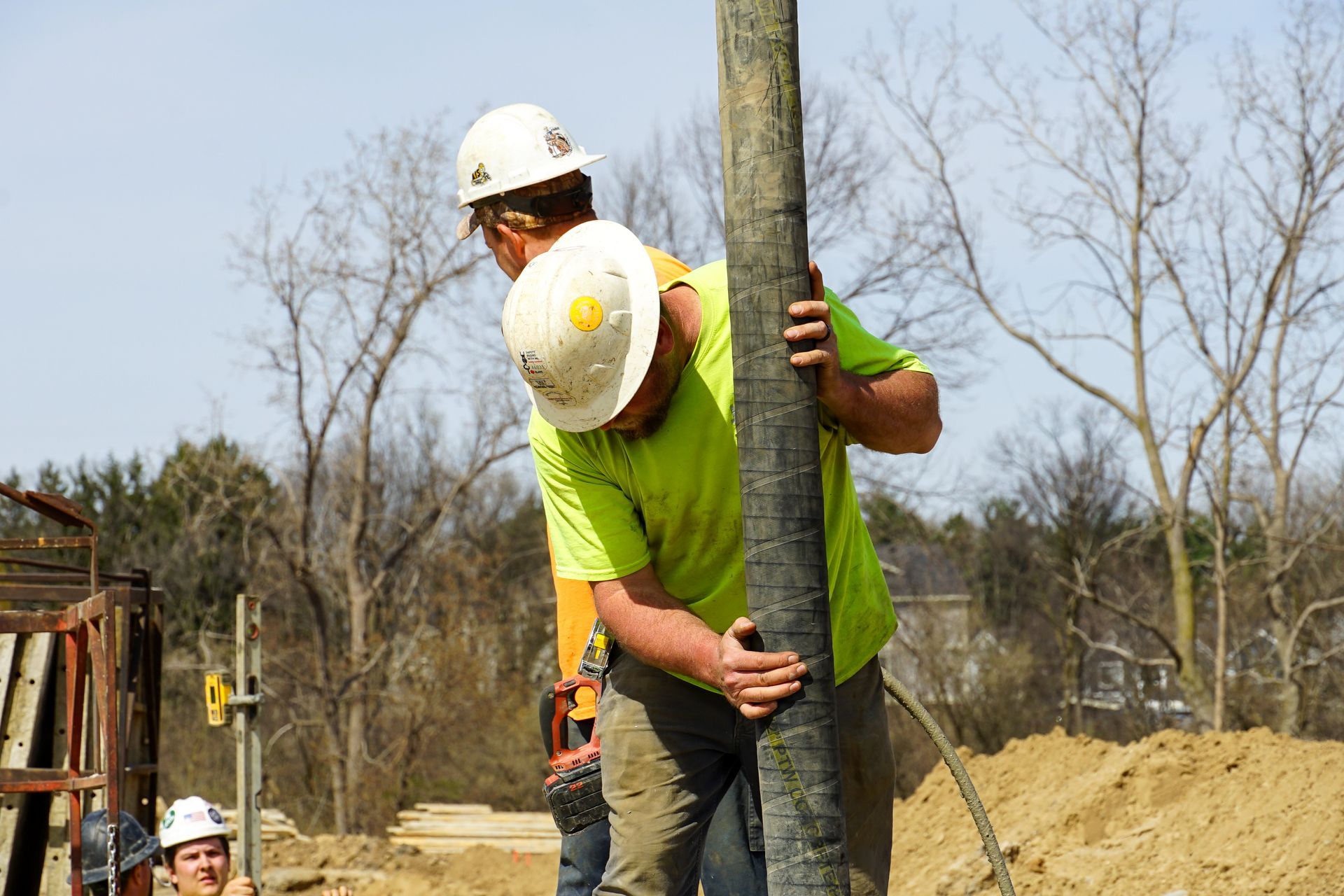 A man wearing a hard hat is holding a pole.