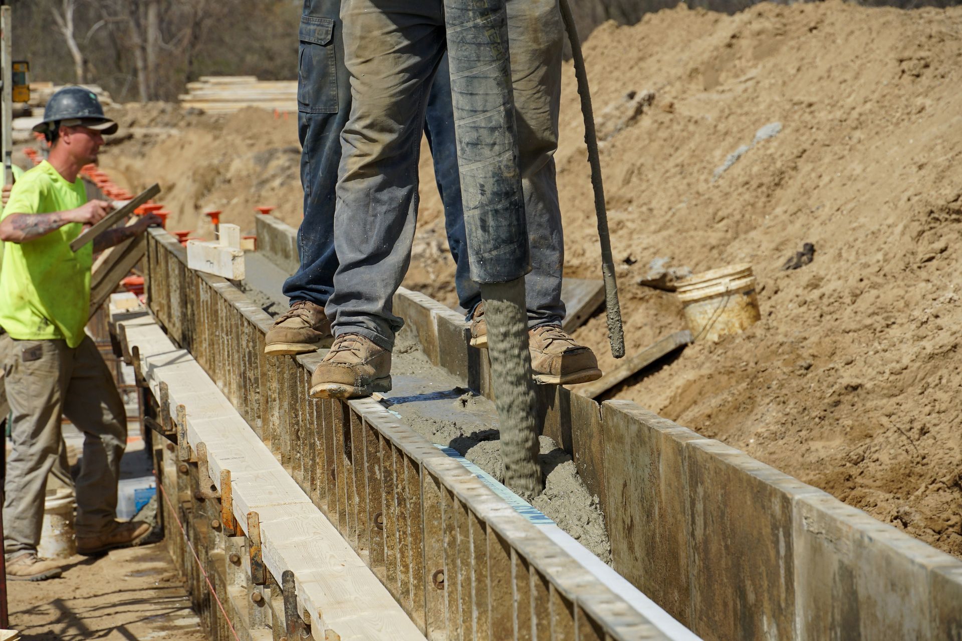 A group of construction workers are working on a concrete wall