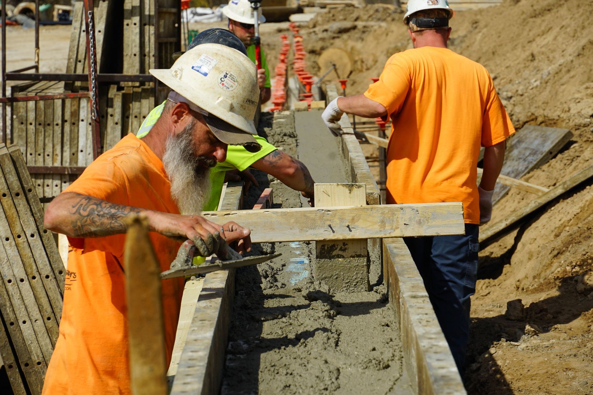A group of construction workers are working on a concrete wall