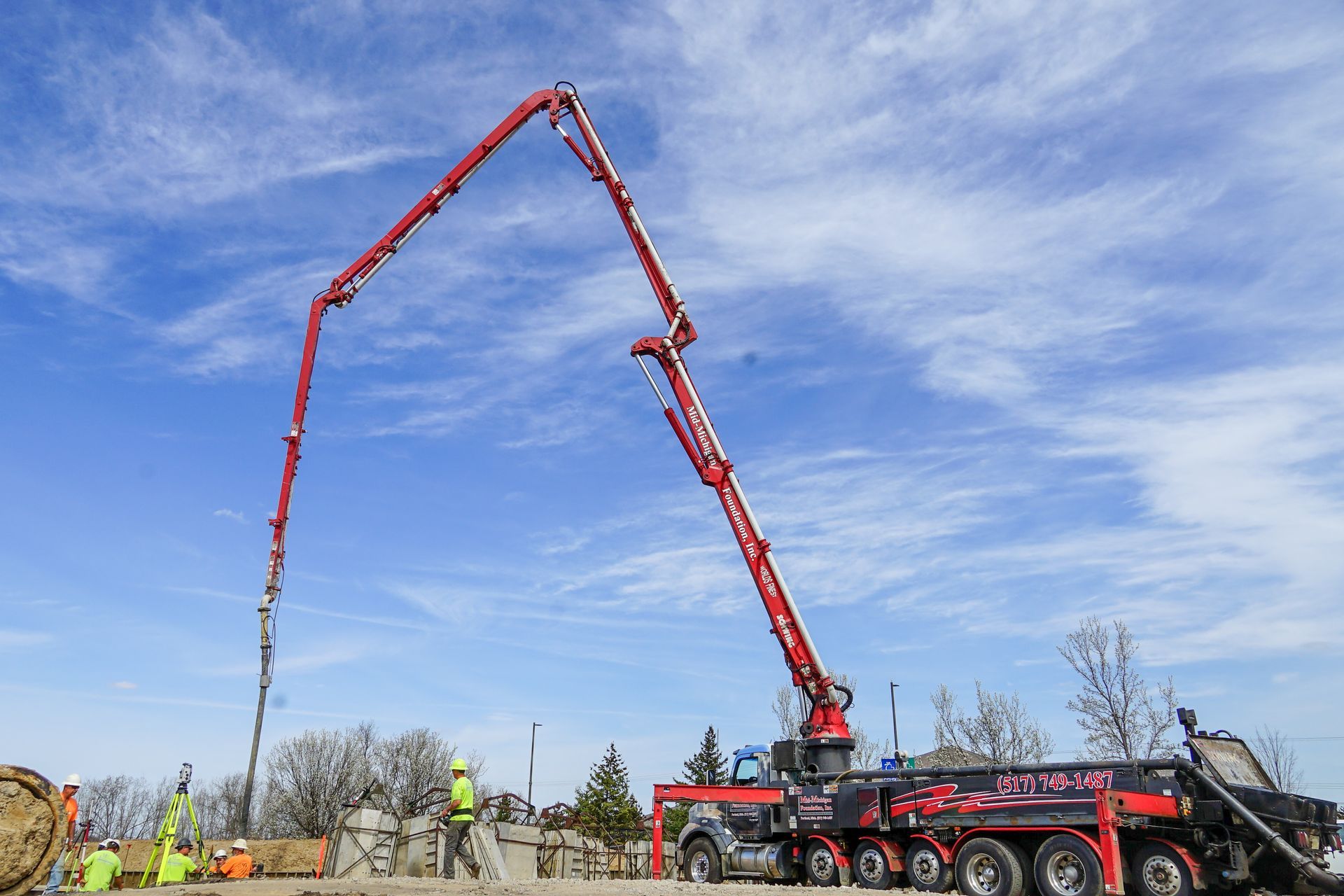 A concrete pump is being used to pour concrete on a construction site.