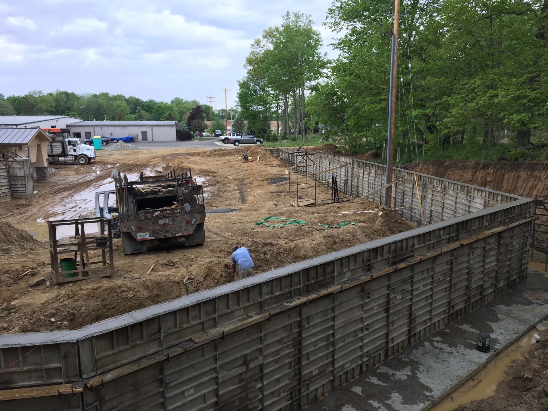 A large concrete wall is being built on a construction site.
