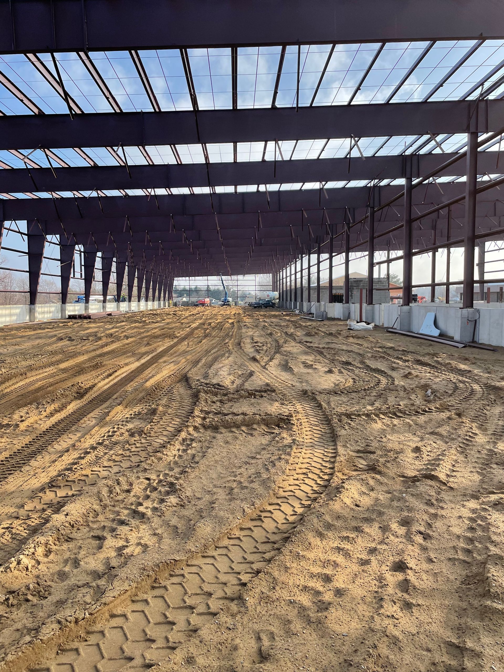 A large building under construction with a lot of dirt on the ground.