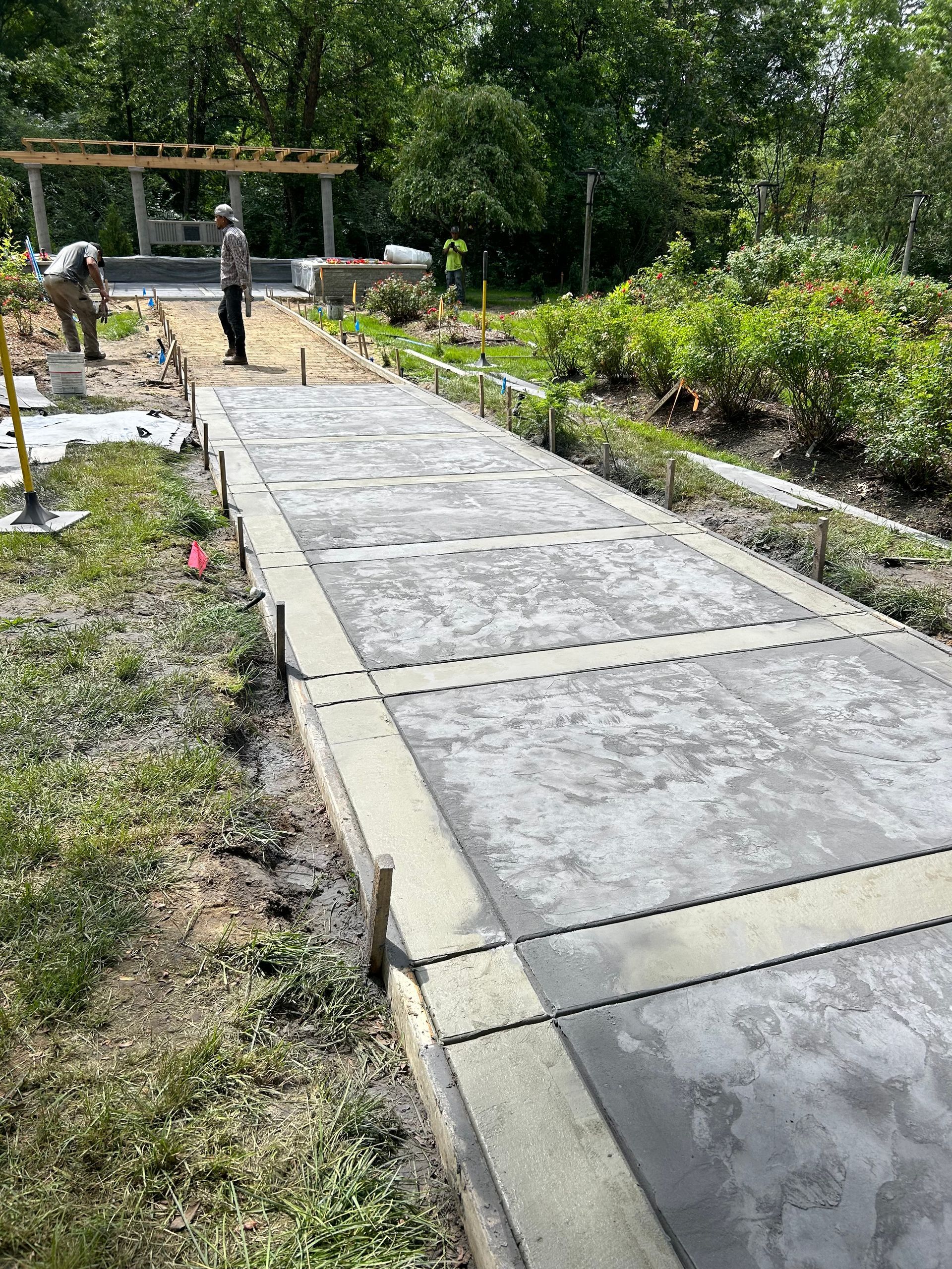 A concrete walkway is being built in a garden.