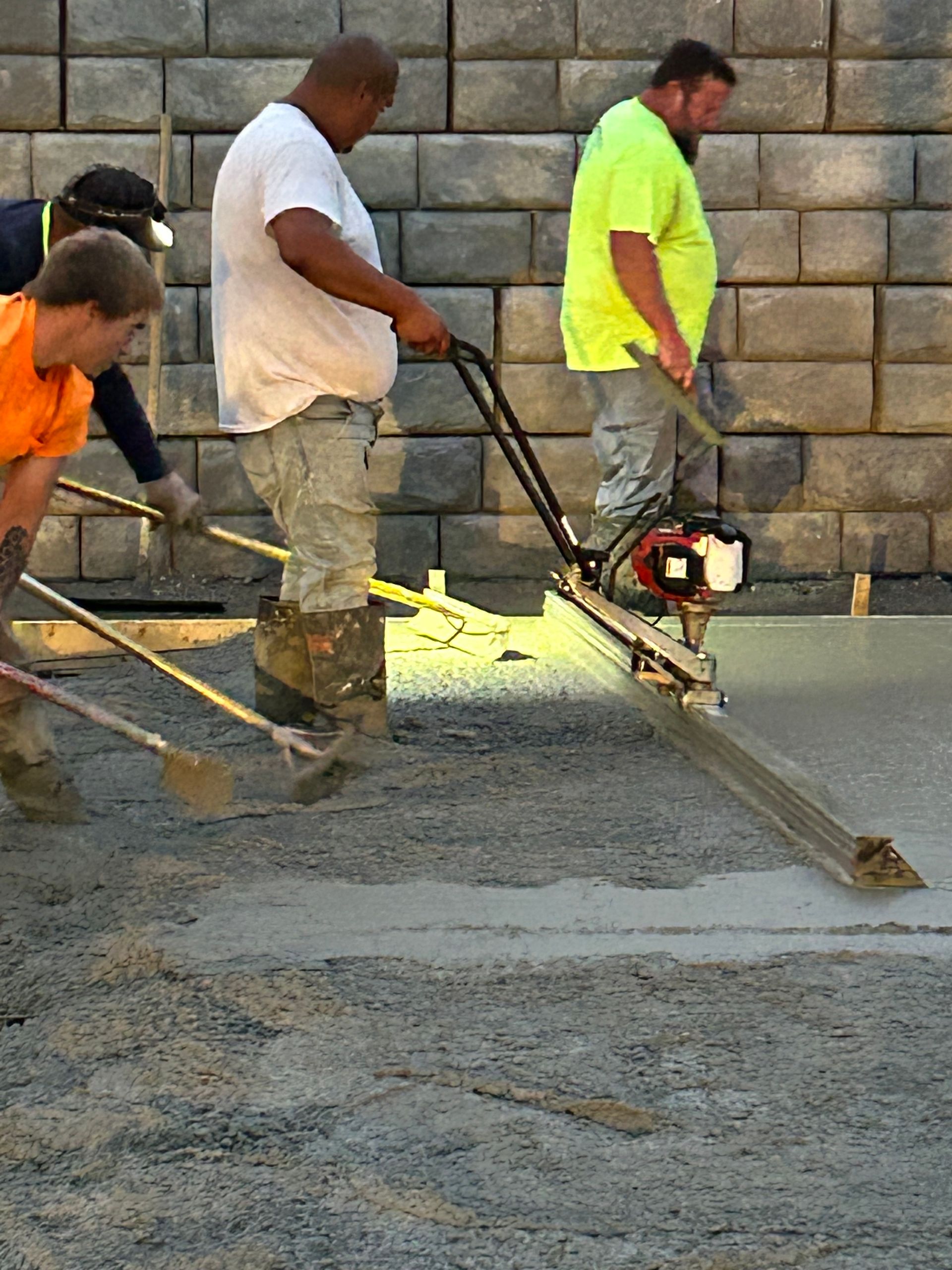 A group of construction workers are working on a sidewalk