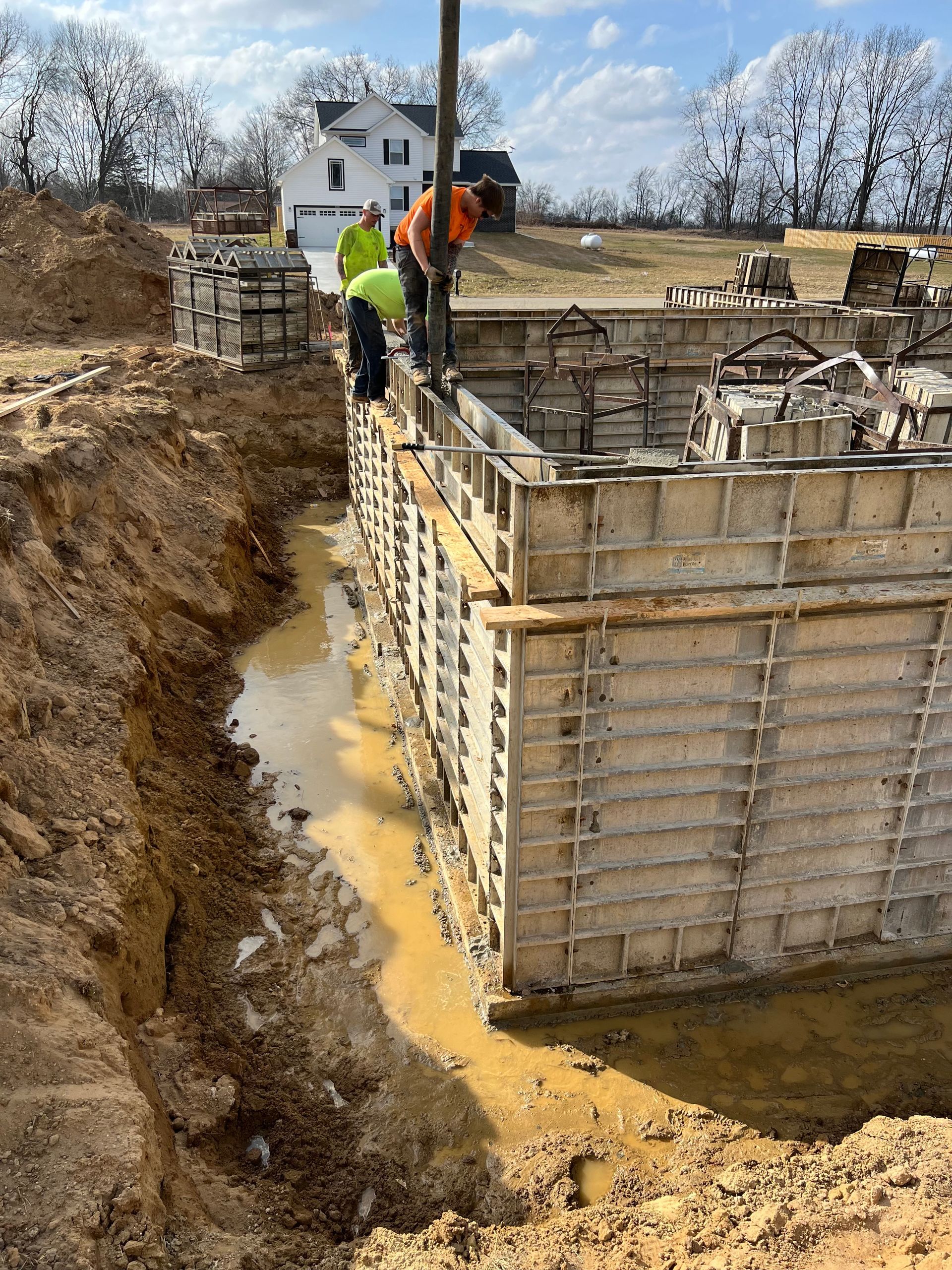 A group of construction workers are working on a concrete wall.
