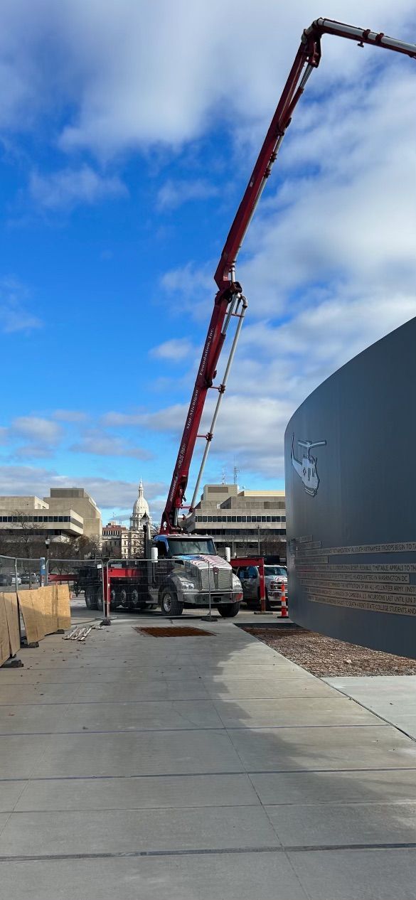 A concrete pump is being used to pour concrete into a building.