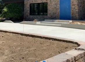 A concrete driveway is being built in front of a brick building.