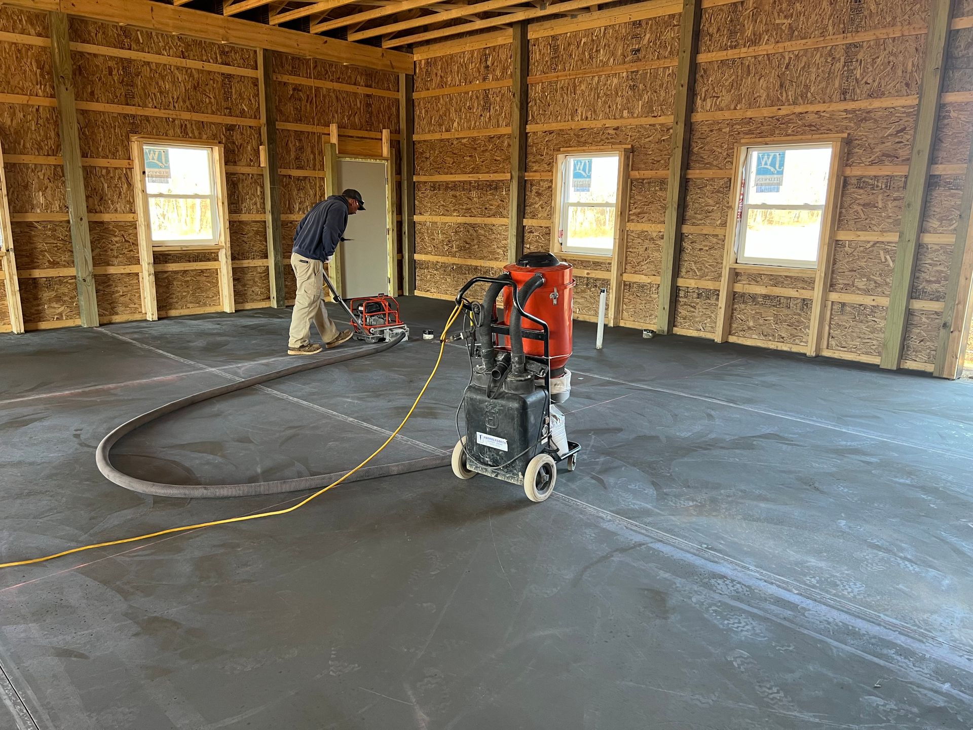 A man is using a vacuum cleaner to clean the floor of a building.