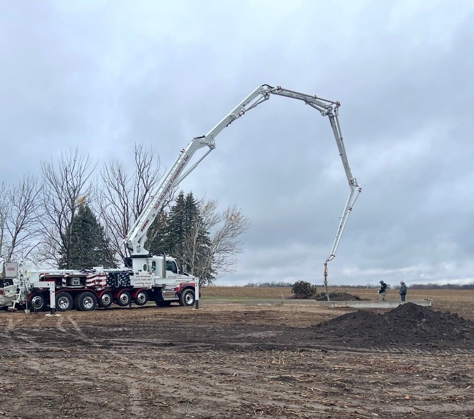A concrete pump is being used to pour concrete on a construction site.
