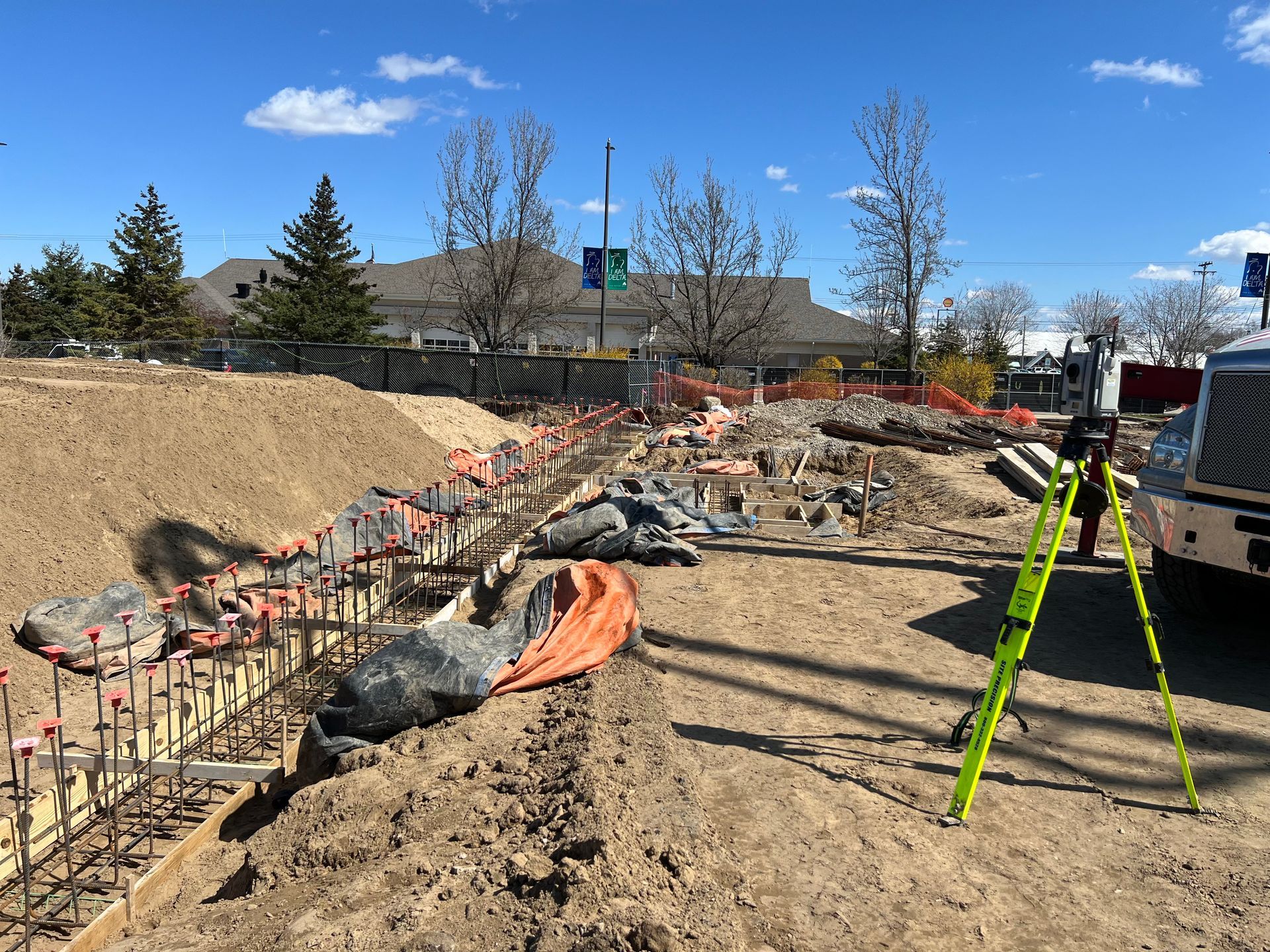 A construction site with a truck and a ladder in the dirt.