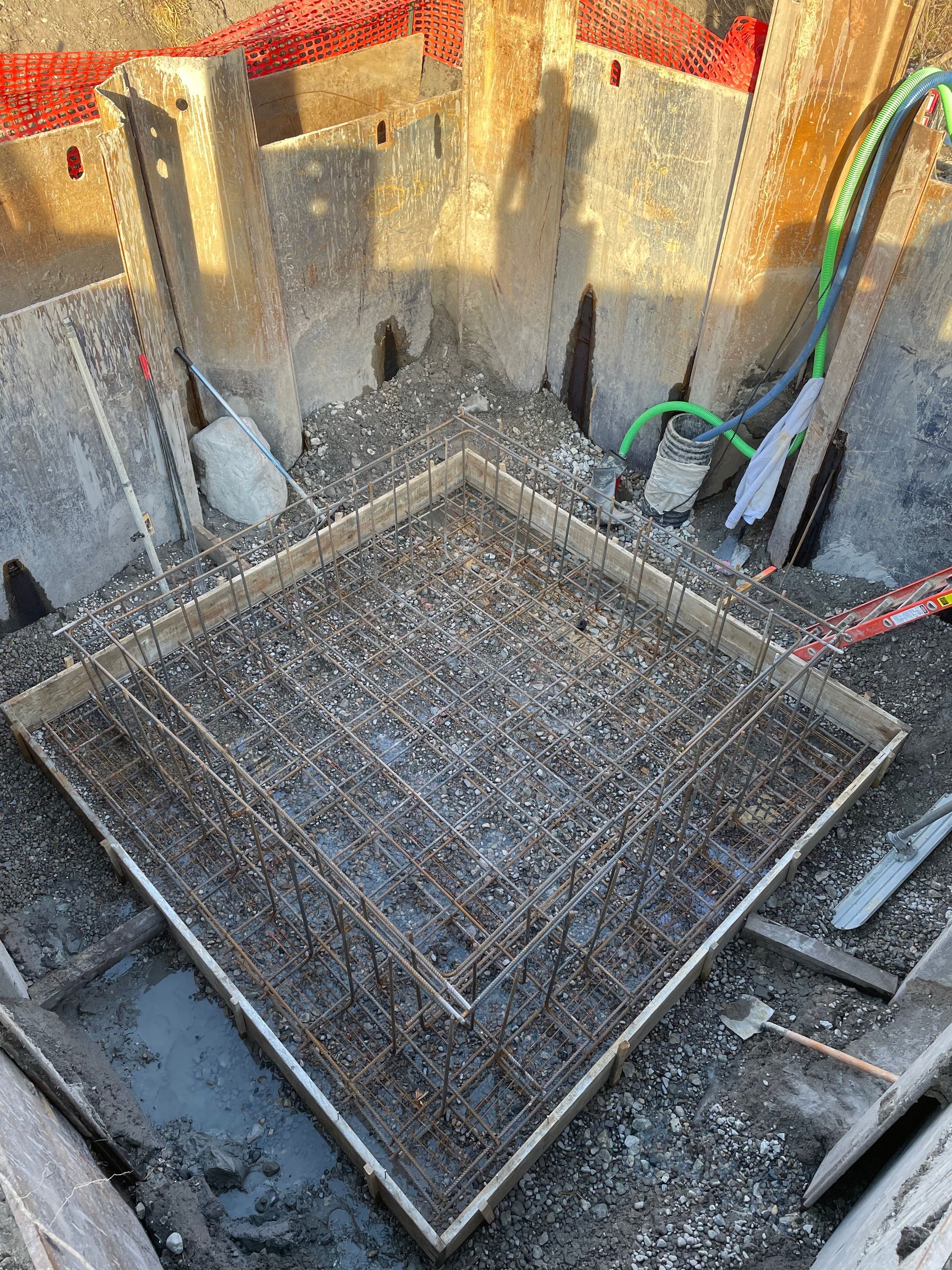 A square of concrete is being poured on a construction site.
