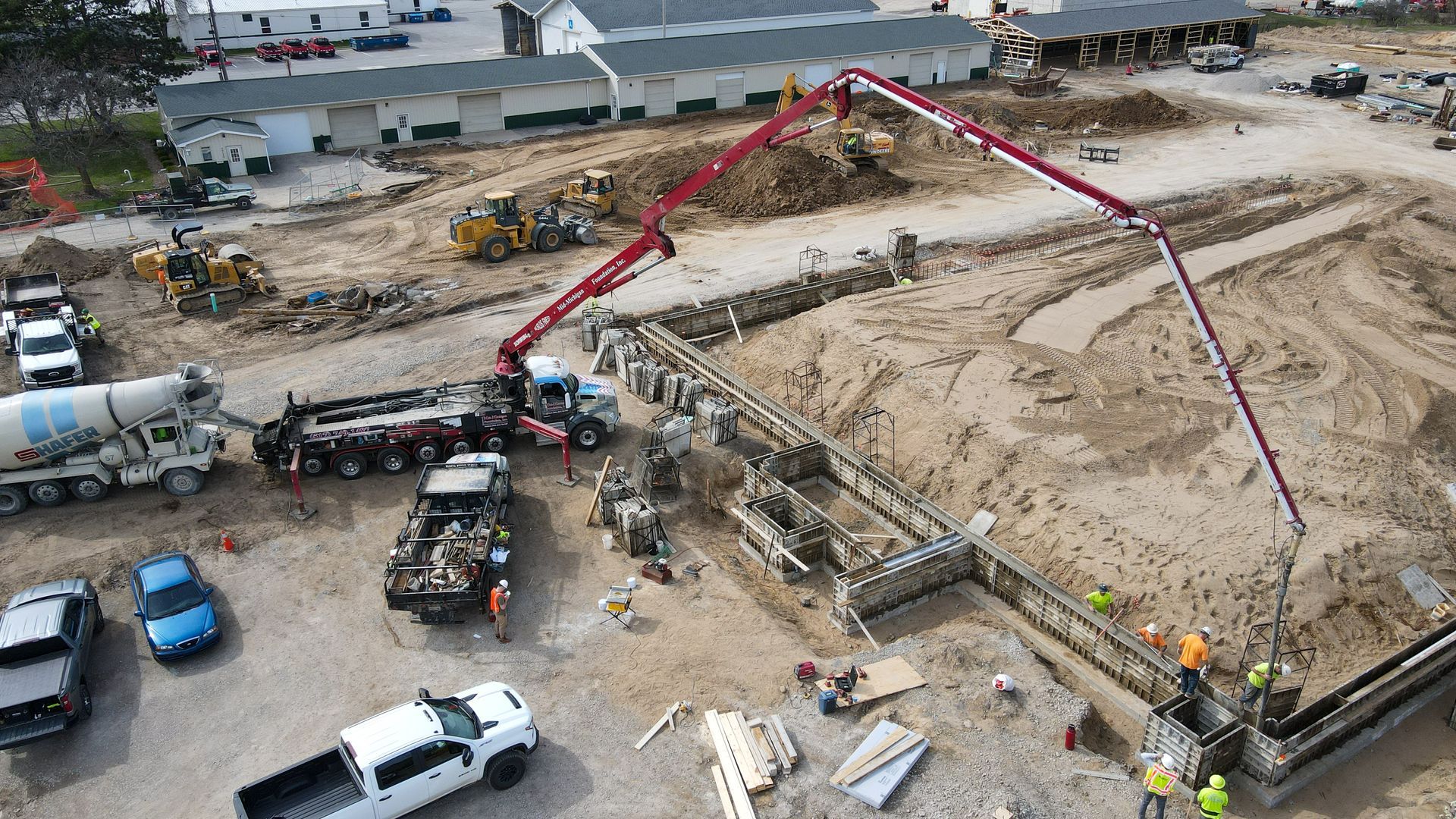 An aerial view of a construction site with trucks and a crane.