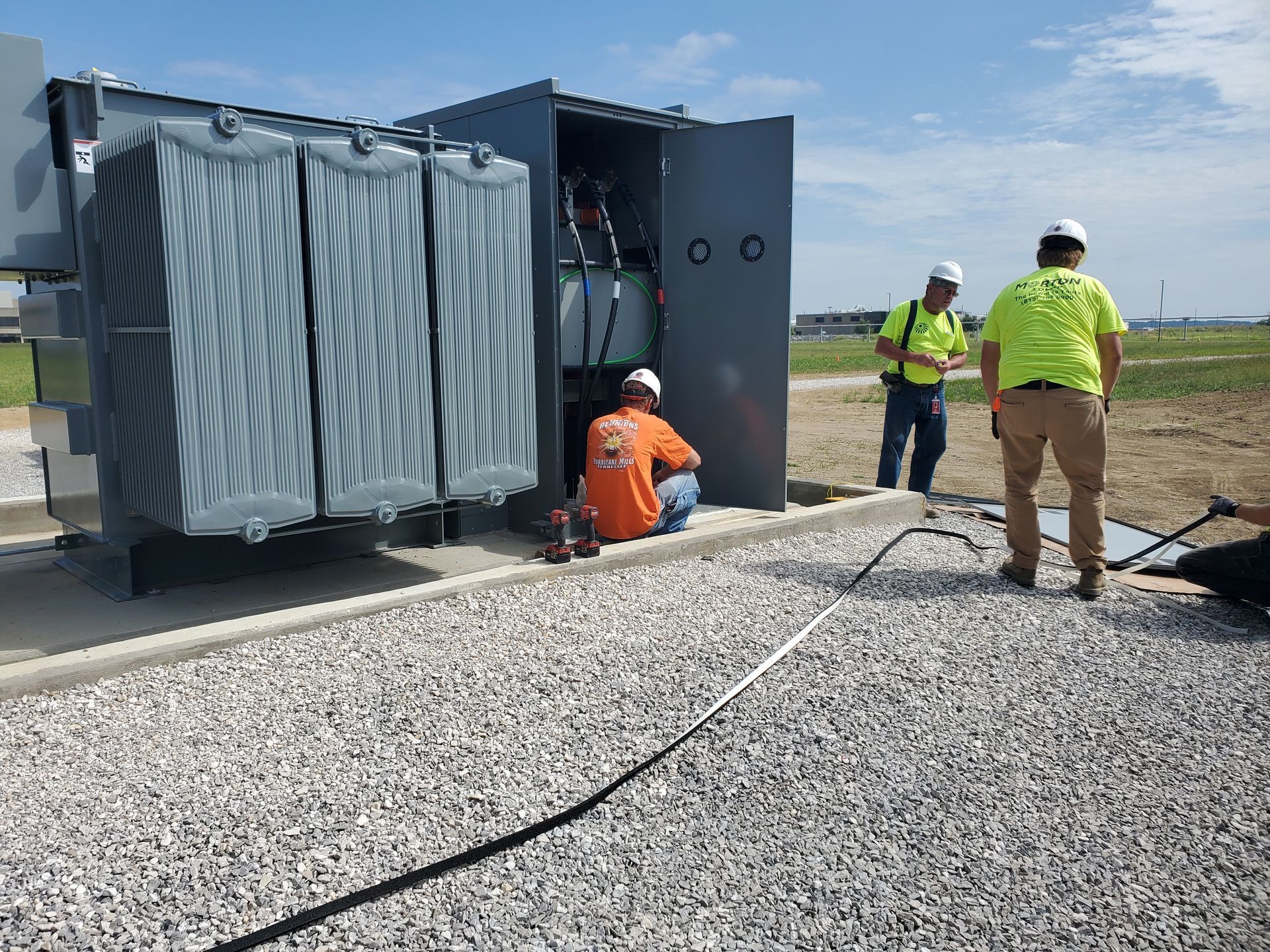 A group of men are working on a large transformer.