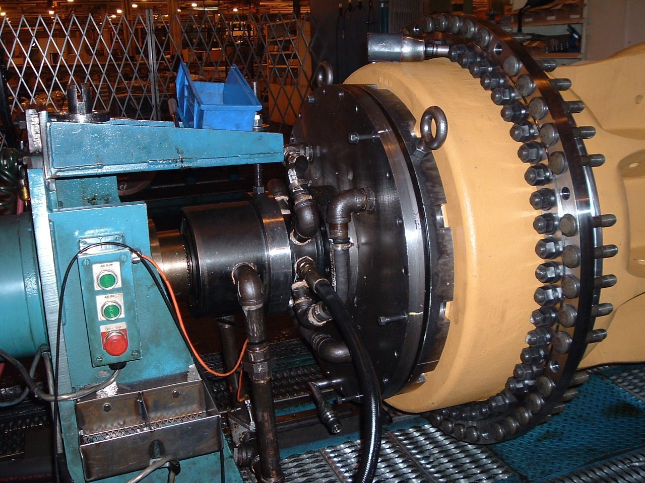 Industrial machine with a large, yellow cylindrical component and intricate piping.