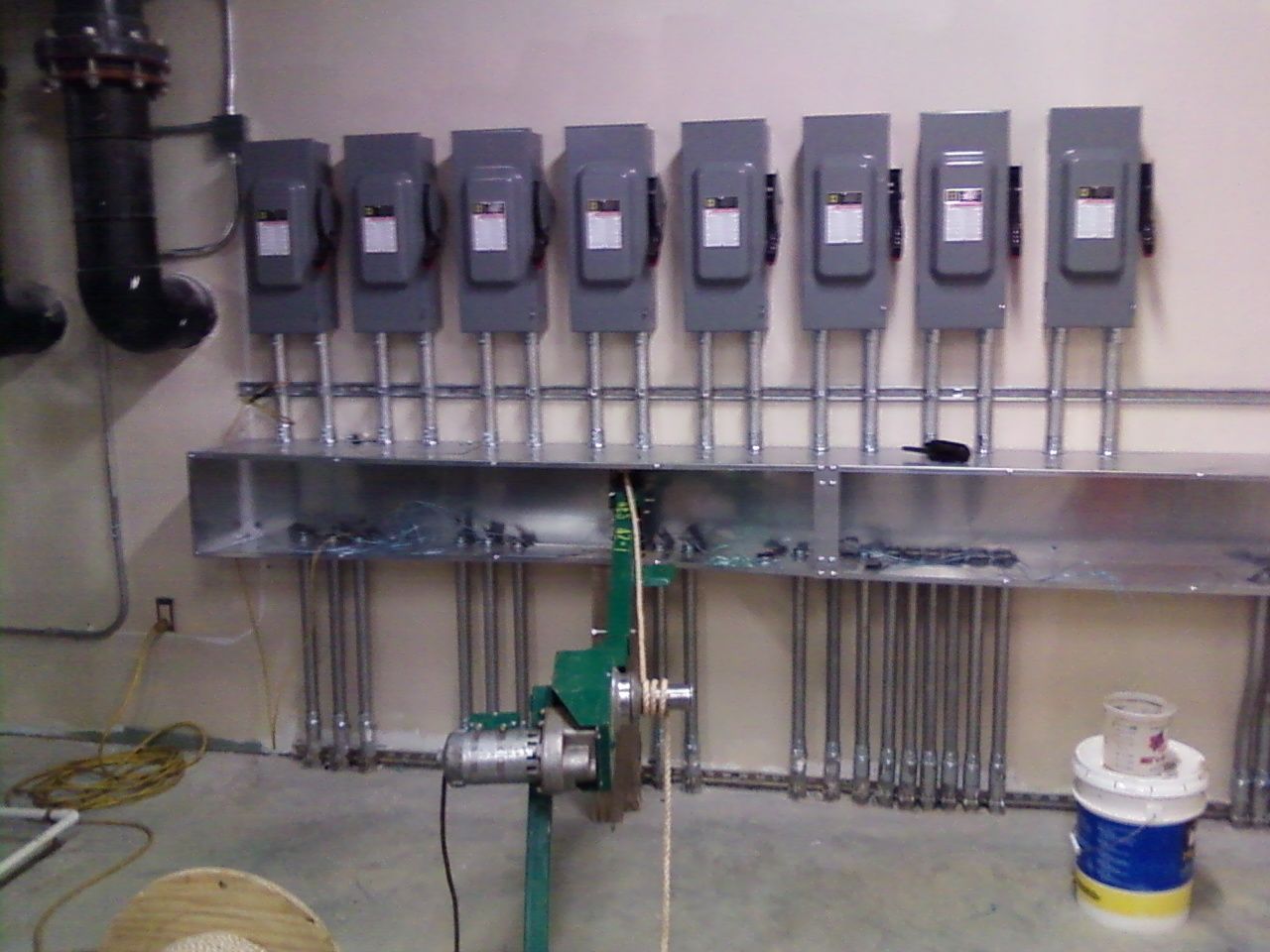 Electrical panel array with conduit in a basement setting.