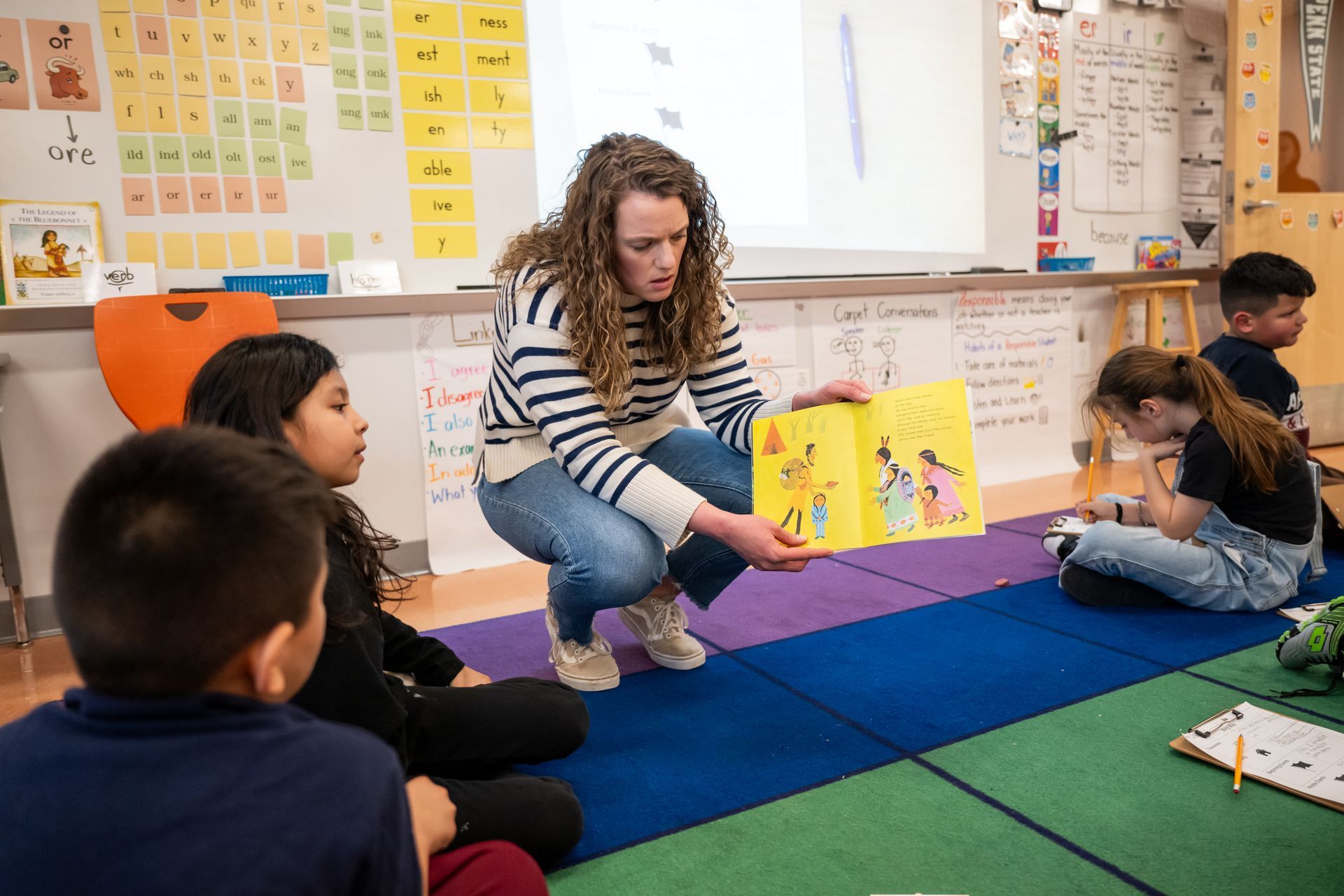 Female teaching showing her class a book