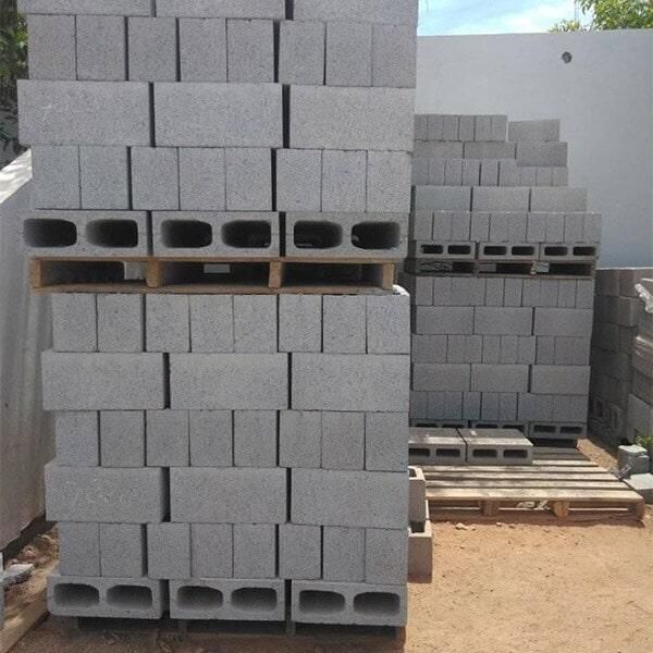 Bloques de hormigón gris apilados sobre palets de madera al aire libre.