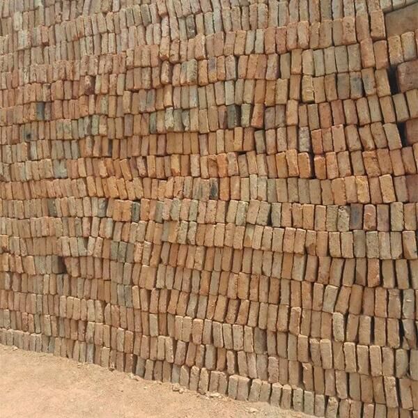 Pila de ladrillos de color marrón rojizo, posiblemente en un sitio de construcción.