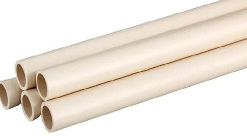 Varios tubos de PVC de color crema apilados juntos.