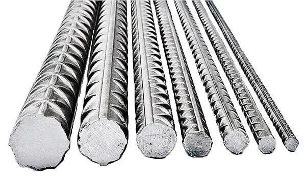 Varillas de refuerzo de acero de distintos diámetros, con superficies texturizadas y extremos cortados.