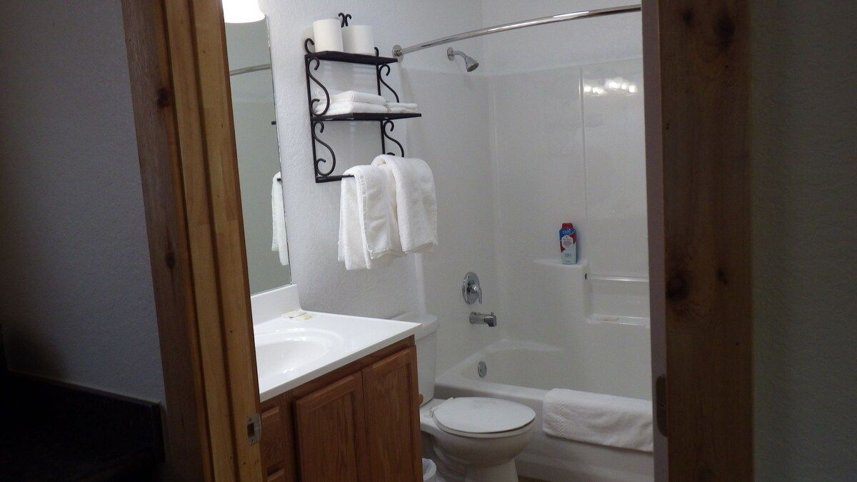 A bathroom with a toilet , sink , and bathtub.