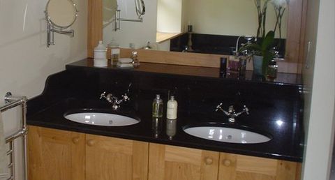 Black granite vanity unit with polished sink and upstand