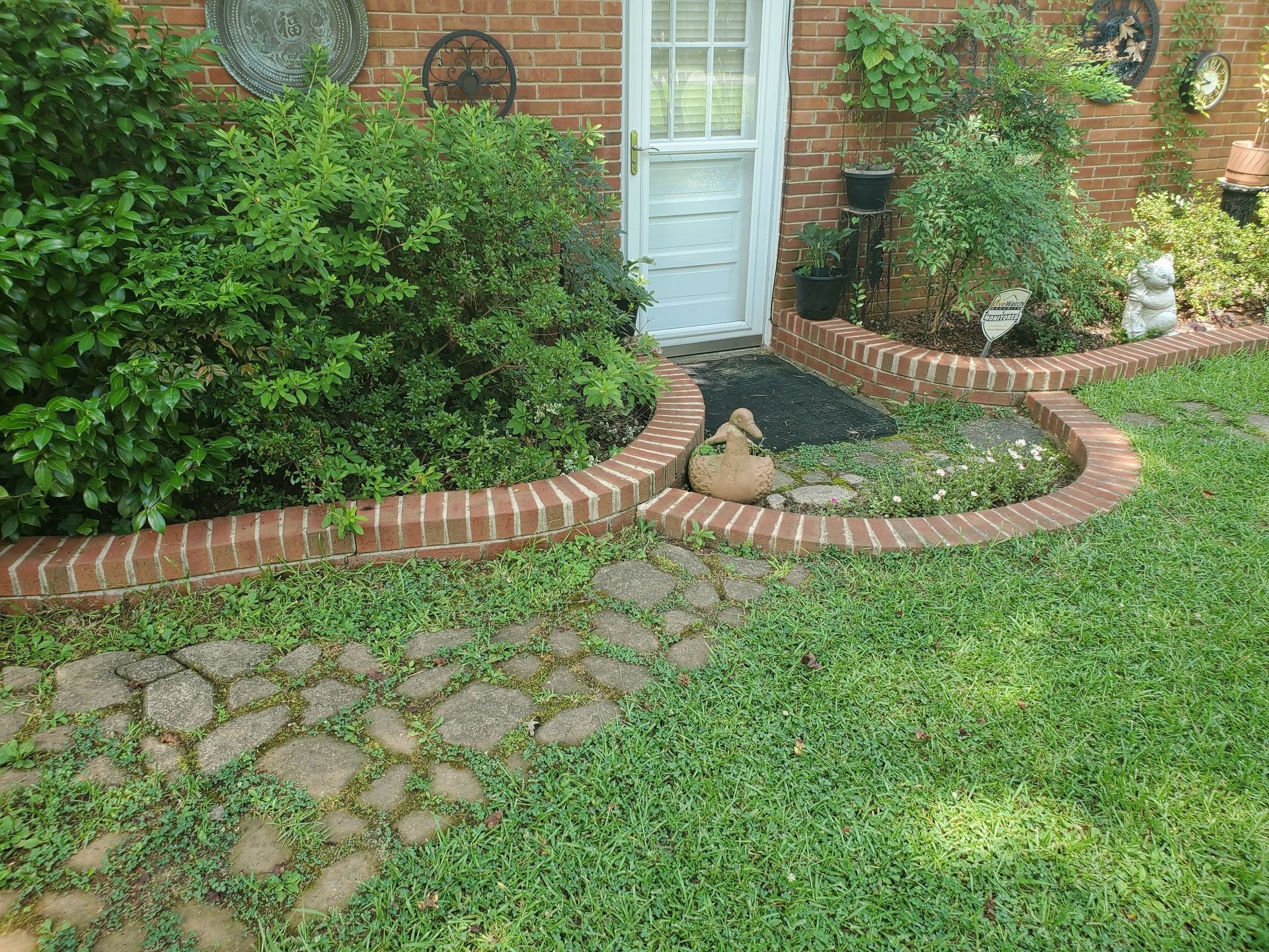 There is a brick walkway leading to the front door of a house.