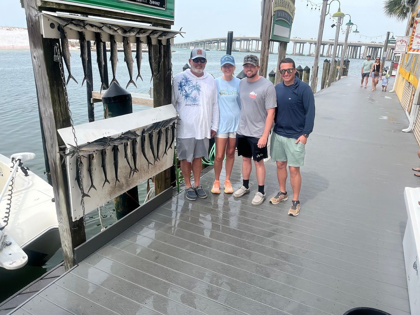 A group of people are standing on a dock next to a boat.