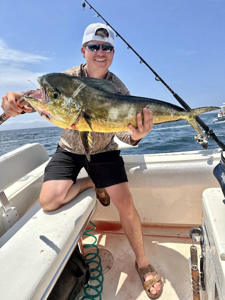 A man is holding a large fish on a boat.