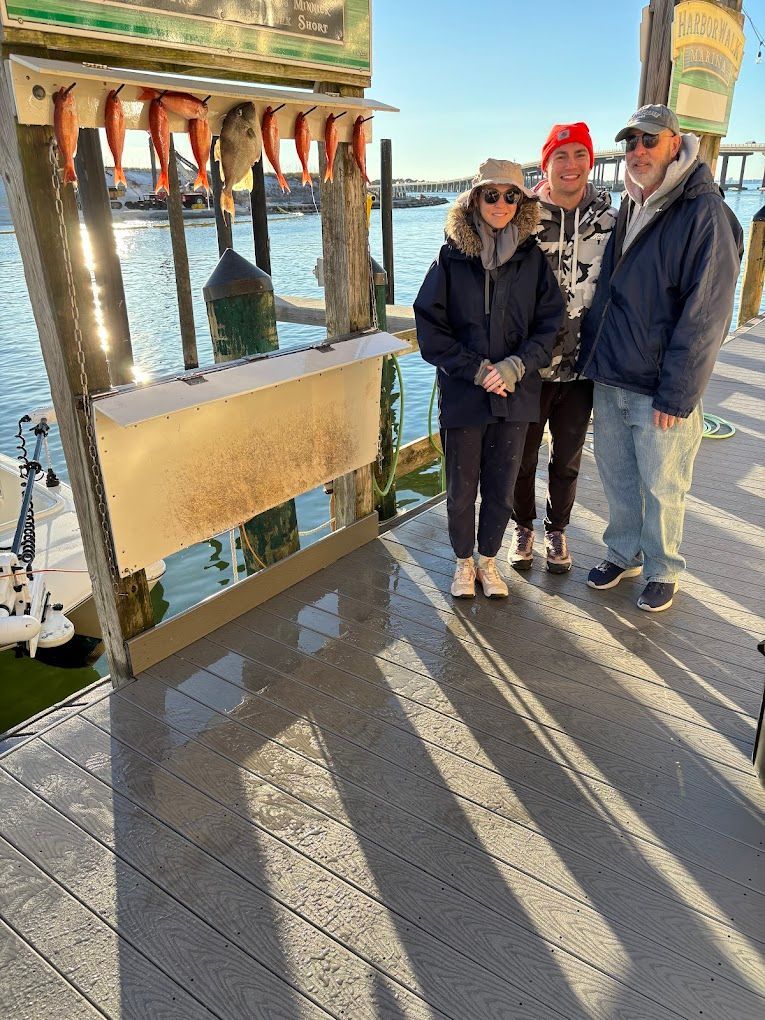 A group of people are standing on a dock next to a boat.