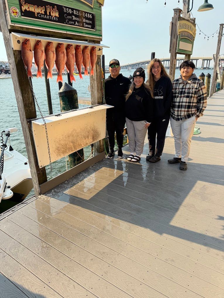 A group of people standing on a dock next to a boat.