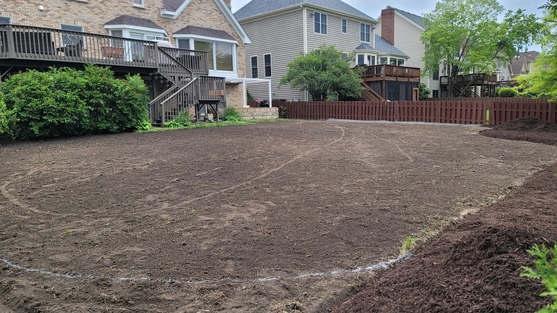 There is a lot of dirt in the backyard of a house.