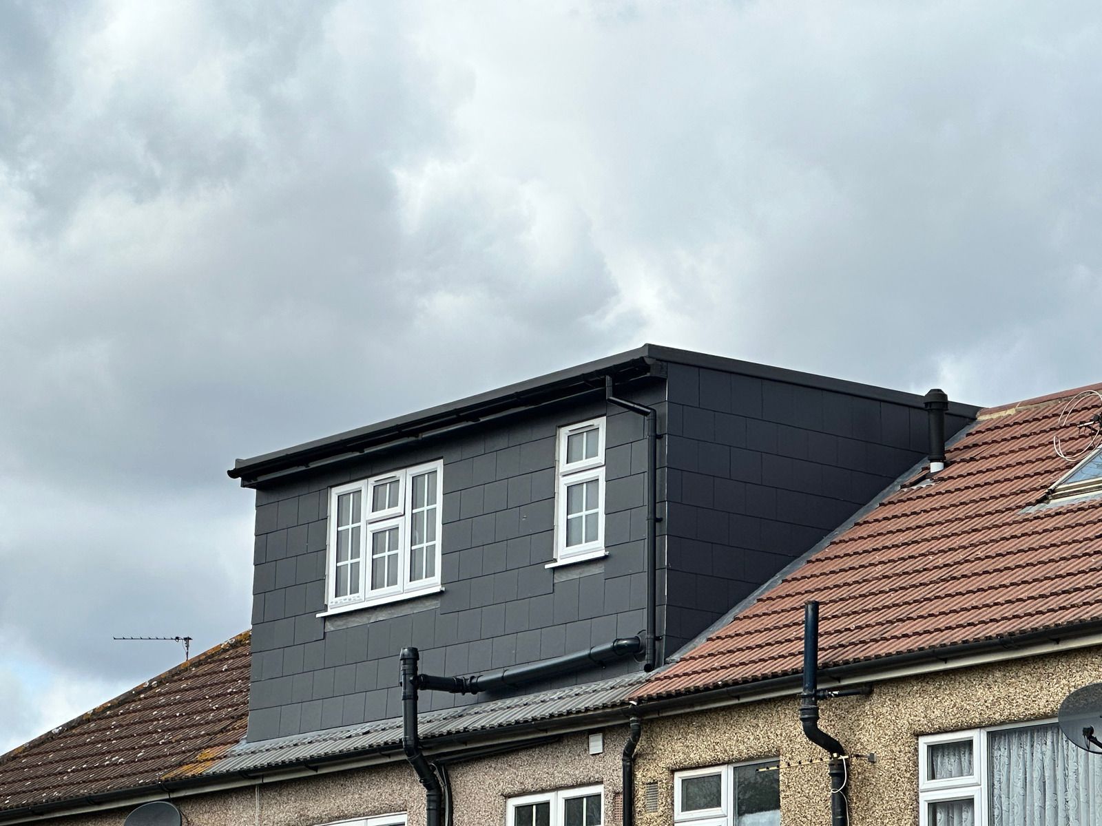 A row of houses with a loft on the top of one of them.