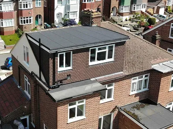 An aerial view of a brick house with a flat roof.