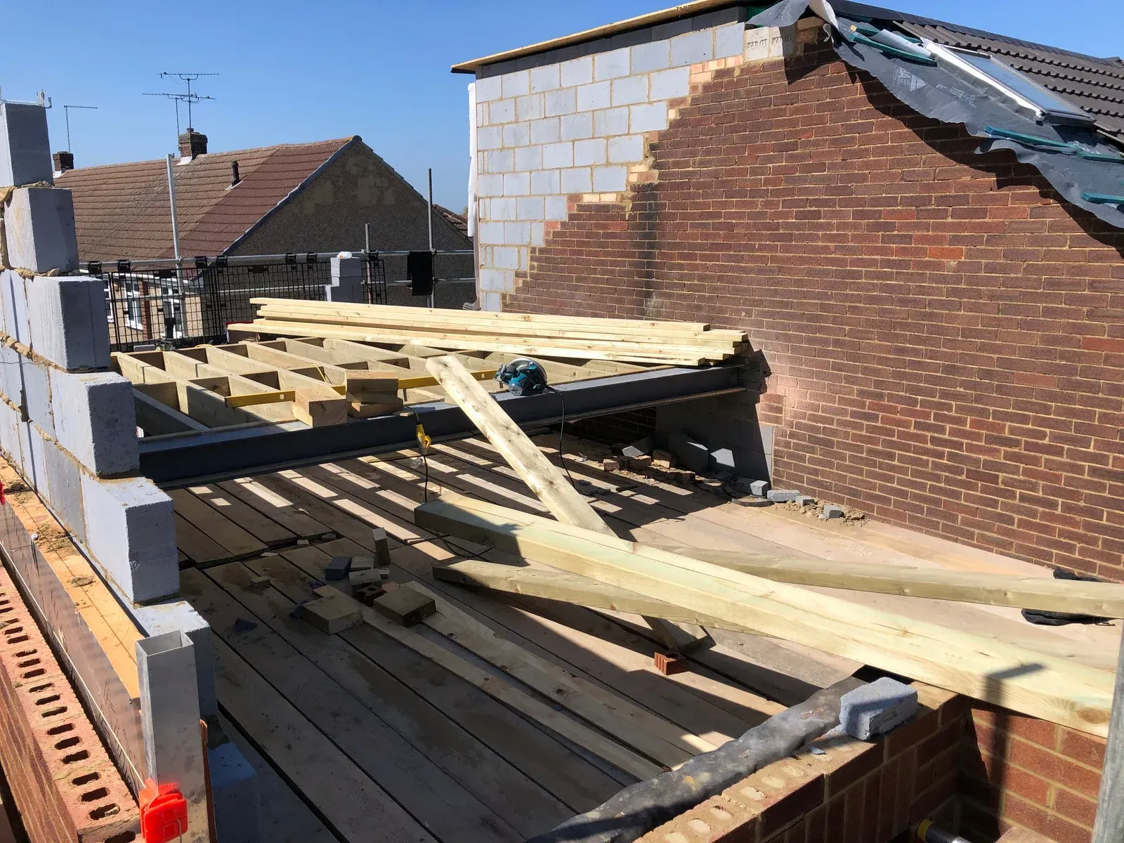 A wooden structure is being built on top of a brick building.