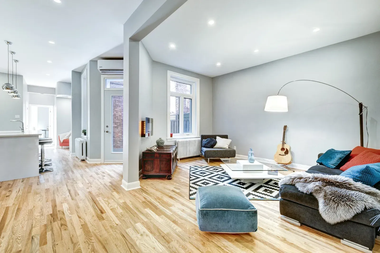 A living room filled with furniture and a guitar on the floor.