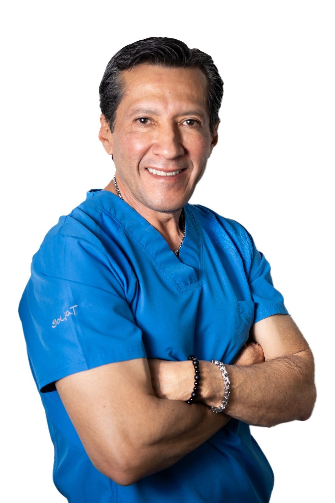 Hombre con uniforme azul, con los brazos cruzados y sonriendo.