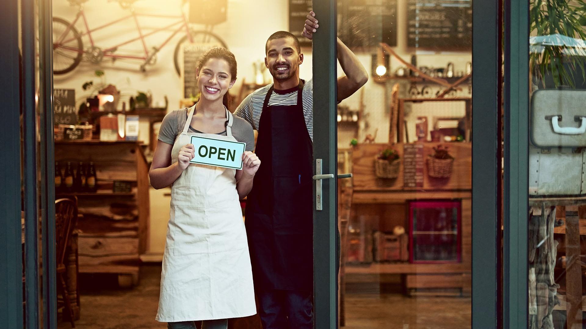 man and woman stand in the door of their business