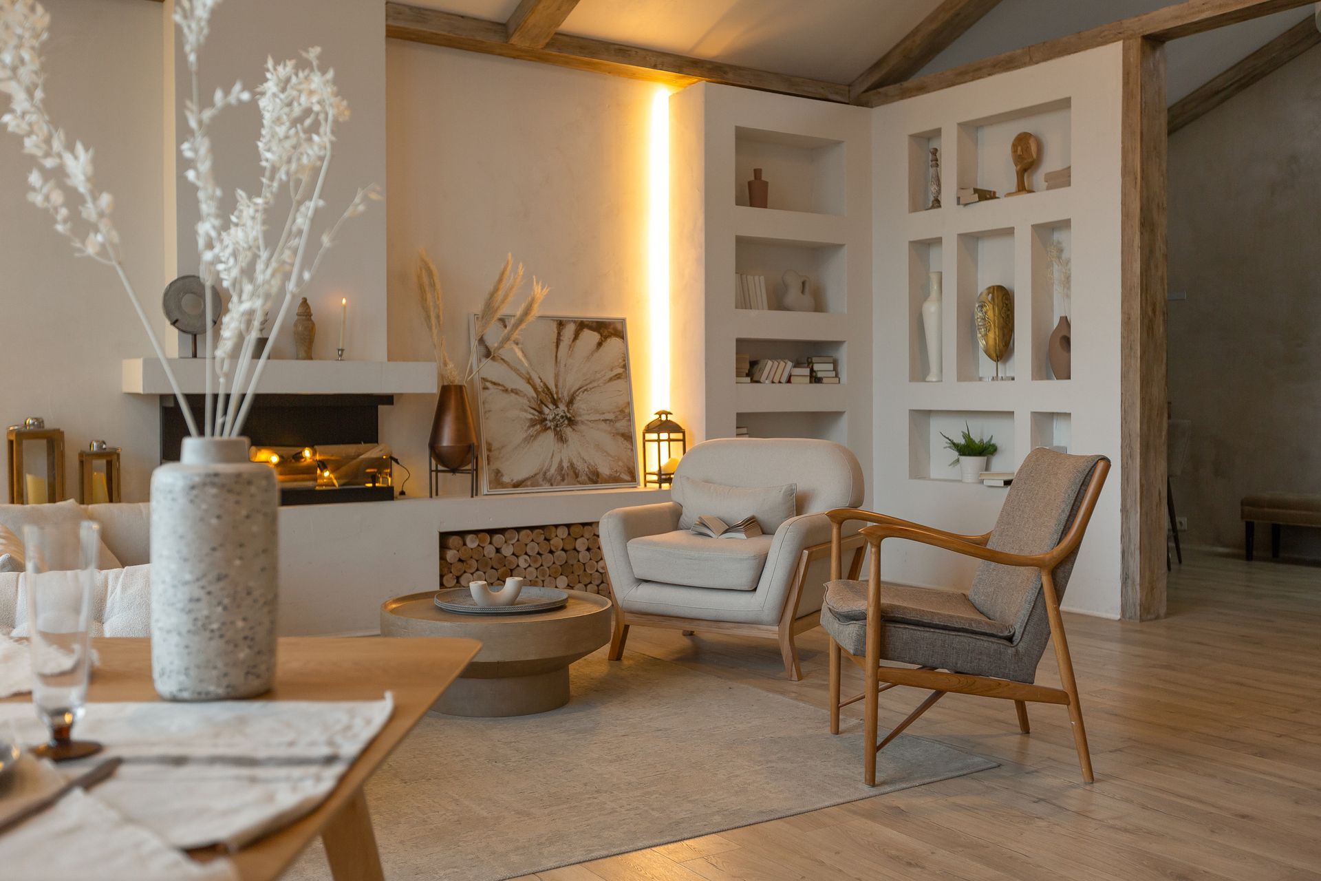 A modern, neutral-toned living room with a fireplace, armchair, wooden accents, and soft, warm ambient lighting.