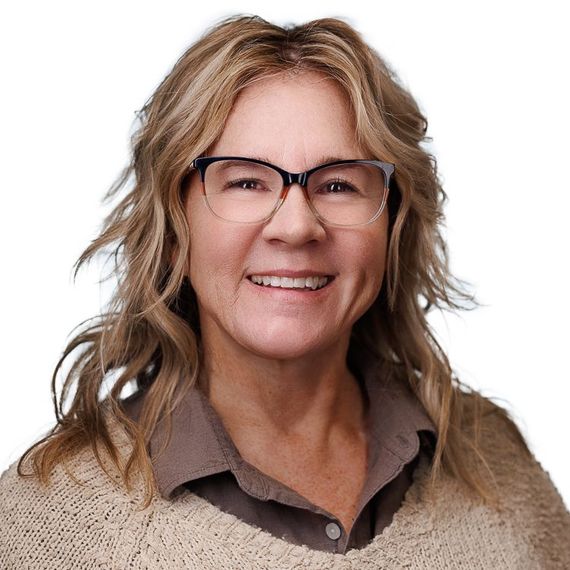 A man and a woman are sitting on a dock overlooking a lake.
