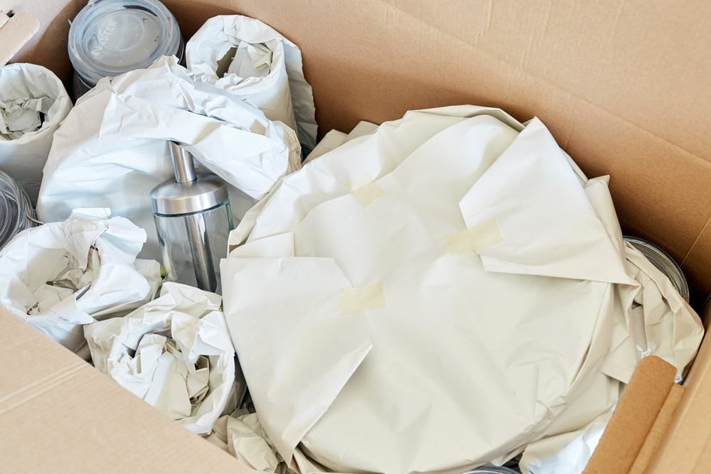 Cardboard Box Filled With Wrapped Dishes and a Silver Dispenser, Ready for Moving — JR Removals Mackay In Dysart, QLD