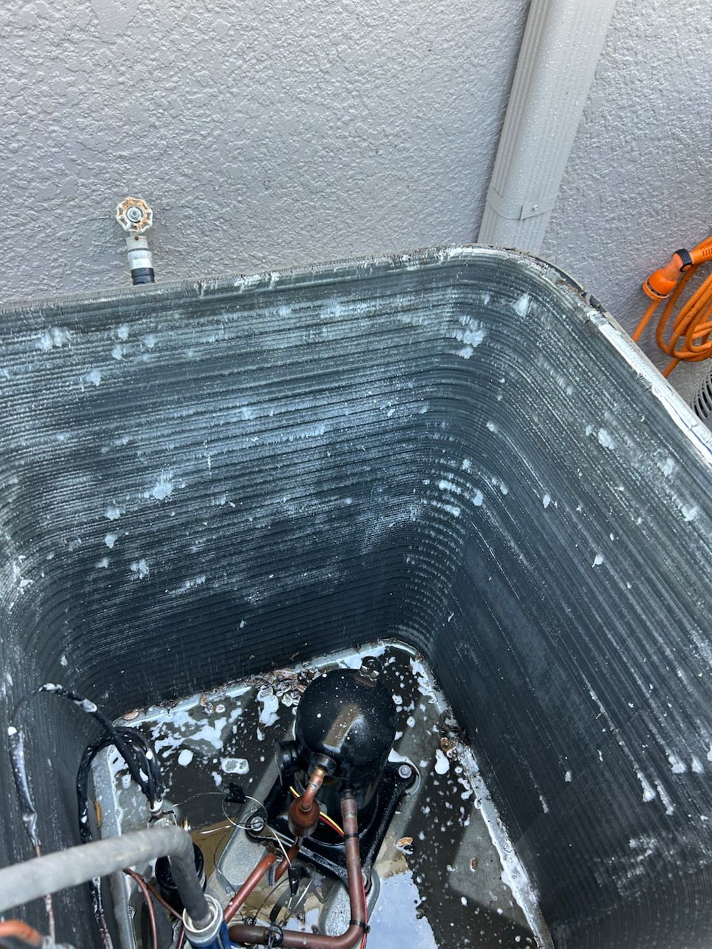 A close up of a dirty air conditioner with water coming out of it.