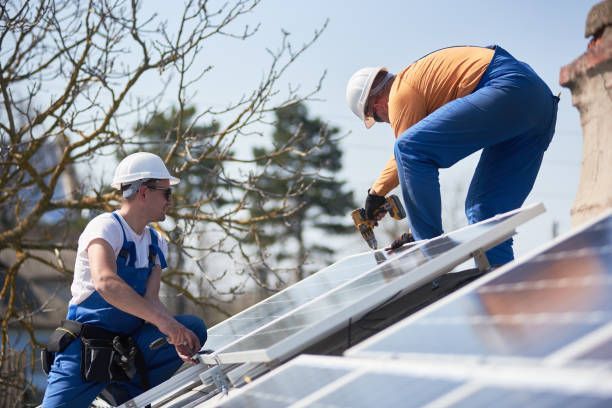 Two solar panel workers installing solar panels on a roof.