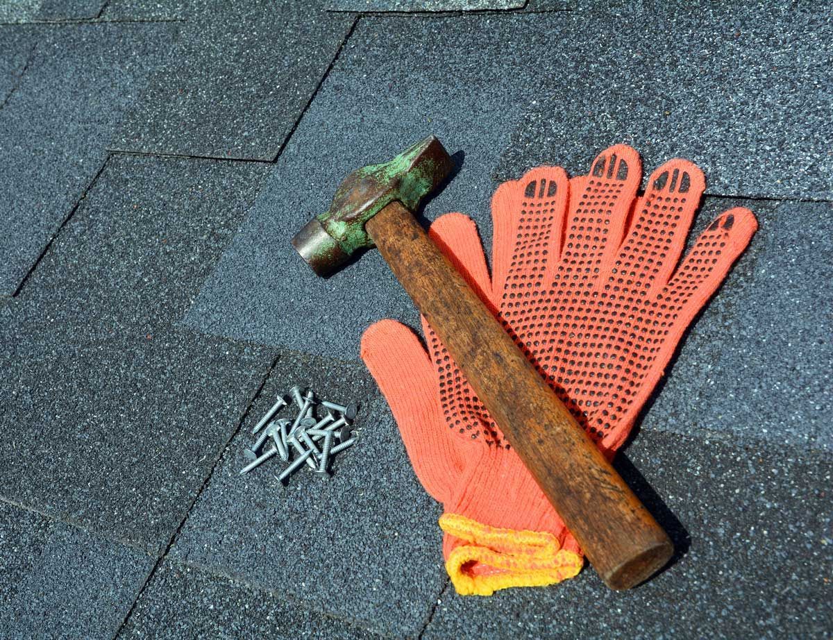 A hammer and gloves on a roof